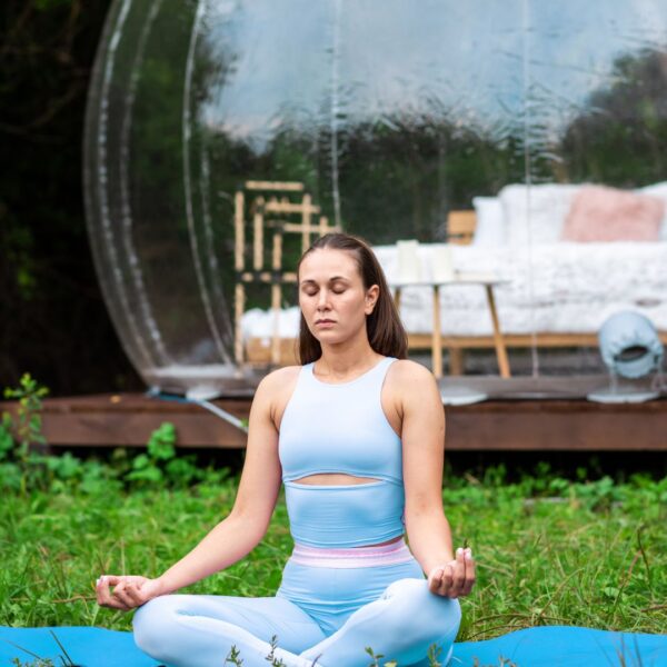 Woman meditating outside geodesic dome